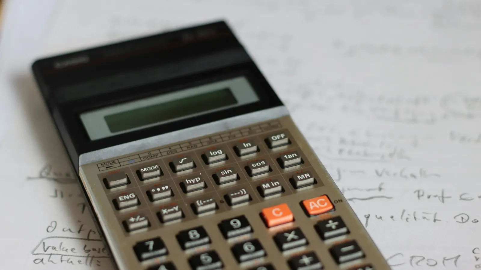 Calculator resting on a sheet of handwritten notes